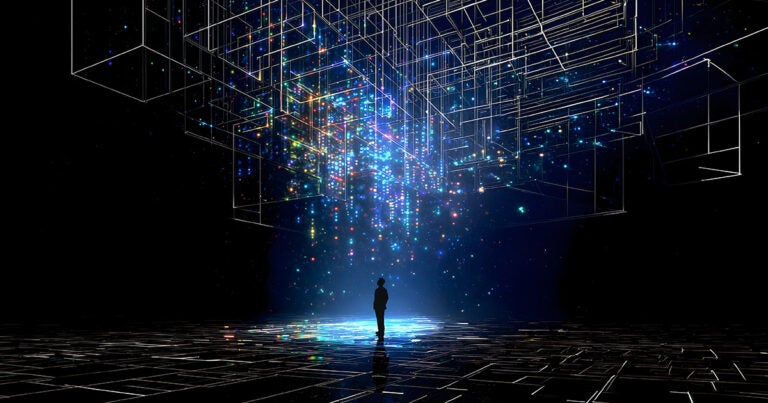 Silhouette of a man standing in a blue spotlight of circuitry