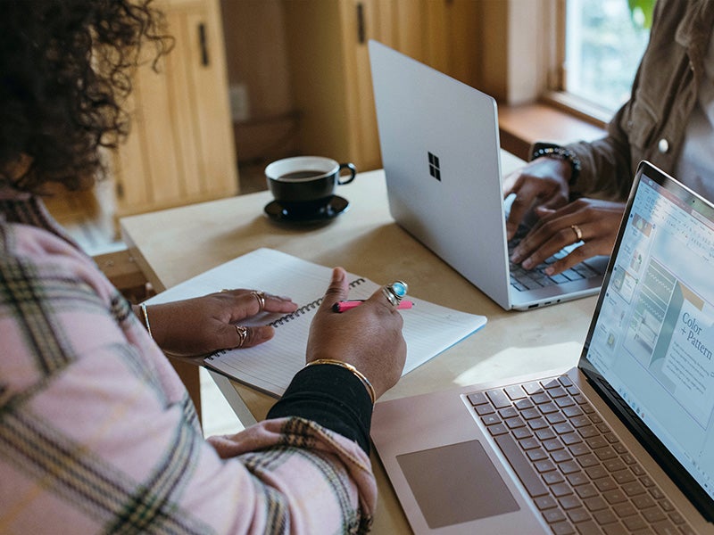 Person using laptop and notebook